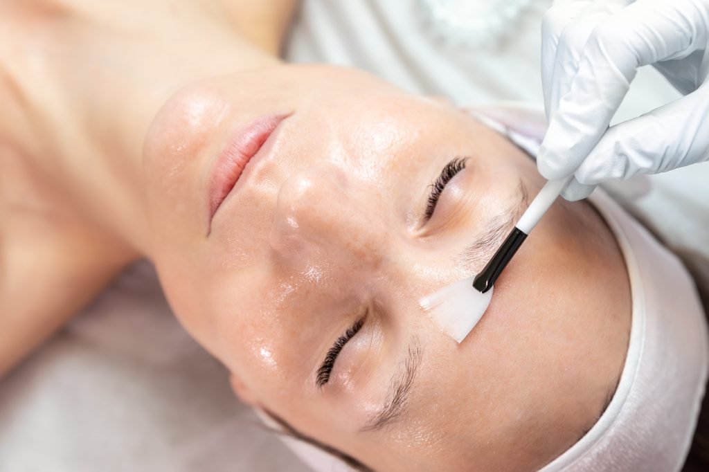 close-up-beautician-doctor-hand-making-anti-age-procedure-apply-peeling-acid-young-female-person